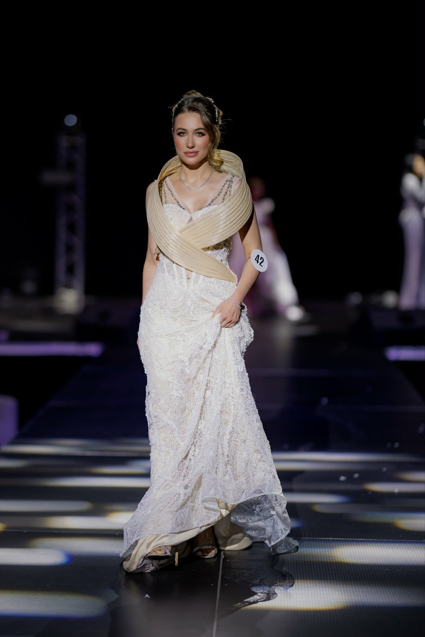 Iryna Vyacheslavivna walking the runway in a white lace gown